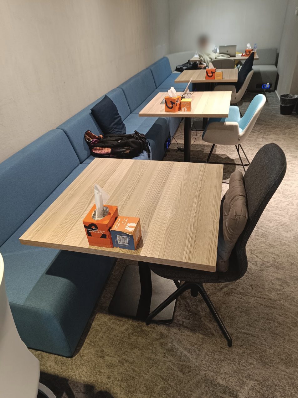 Quiet study lounge with a long blue bench and wooden tables